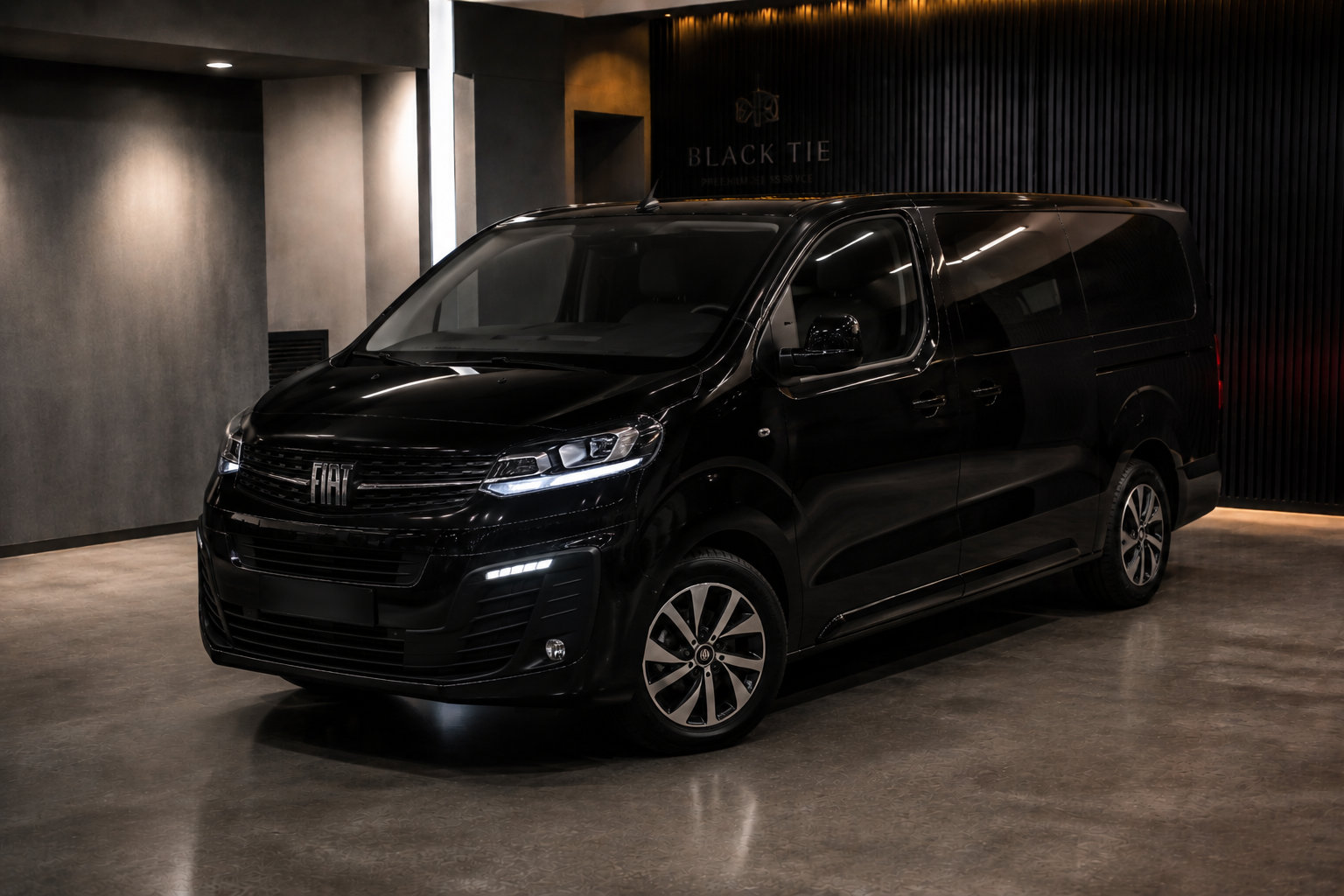 Minivan executiva preta da Black Tie estacionada na garagem da empresa